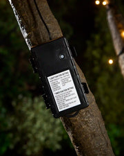 Black 3C Battery Box attached to tree with blurred garden background