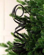 Black Glitter Spiral Swirl Pick hanging from Christmas tree branch with cream background
