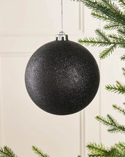 Black glitter oversized 15cm bauble on a Christmas tree branch