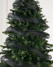 Black mesh ribbon wrapped around Christmas tree against a cream background