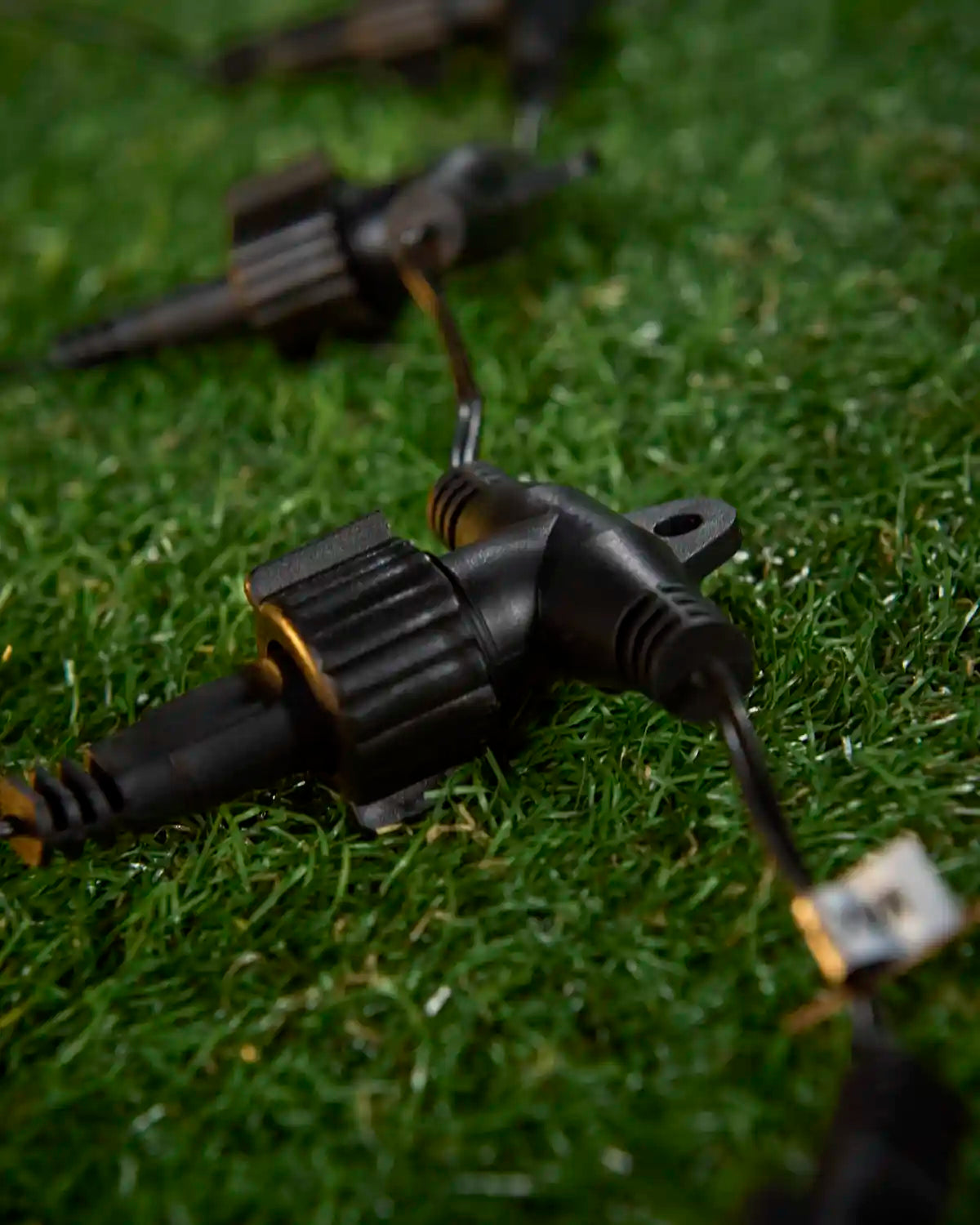Black outdoor light splitter connected in a line on grass