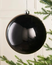 Black oversized gloss bauble on a Christmas tree branch