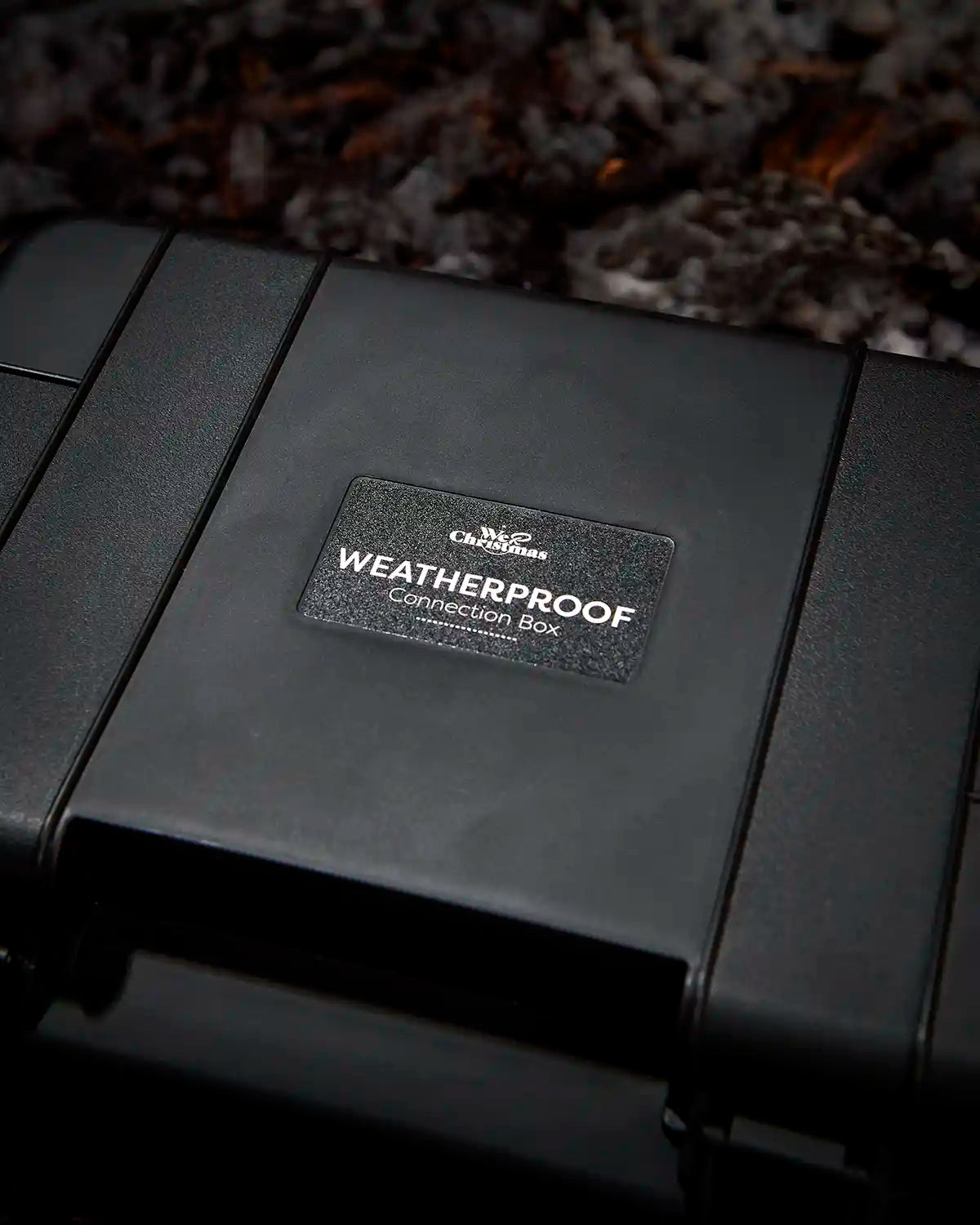 Black weatherproof connection box with a visible We R Christmas brand label on a textured background