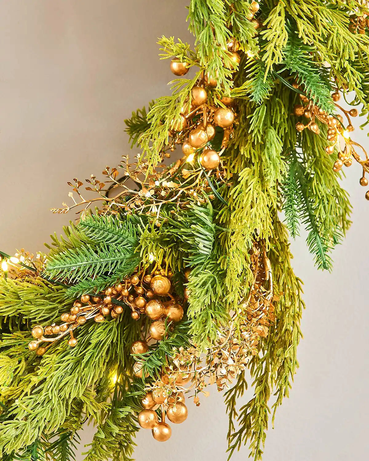 Bottom view Decorative Gold Berry wreath with greenery and small lights on a white background