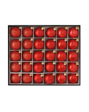Box of small red Christmas baubles on a white background