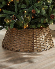 Brown rattan Christmas tree skirt with a decorated tree on a wooden floor