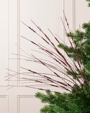 Burgundy Glitter Wispy Spray with long, slender glitter-covered stems arranged in a fan shape on a Christmas tree
