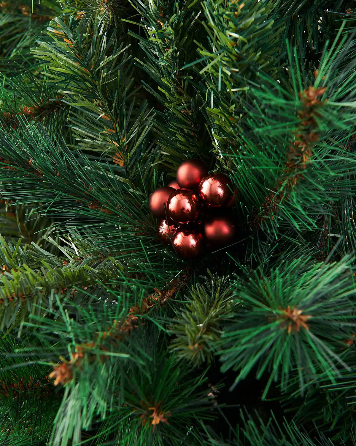 Burgundy berry Cluster Christmas ornaments on a green pine branch