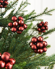 Burgundy cluster baubles on a Christmas tree with a white background 