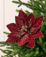 Burgundy glitter artificial poinsettia with layered velvet petals, gold sequin detailing, and gold glitter accents on a Christmas tree