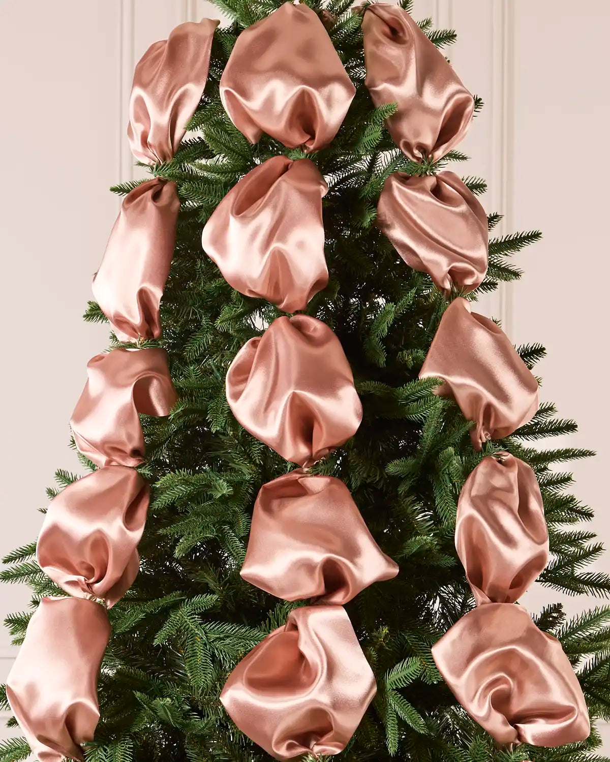 Christmas tree decorated with large rose gold satin ribbons