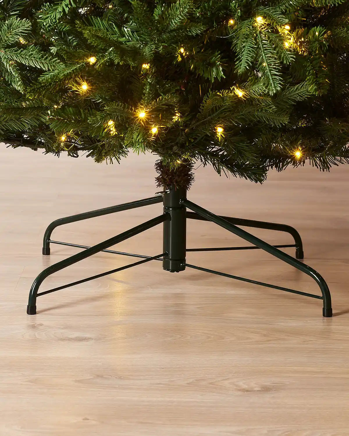 Christmas tree with a stand on a wooden floor