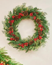 Christmas wreath with greenery, red berries, and pinecones on a light background
