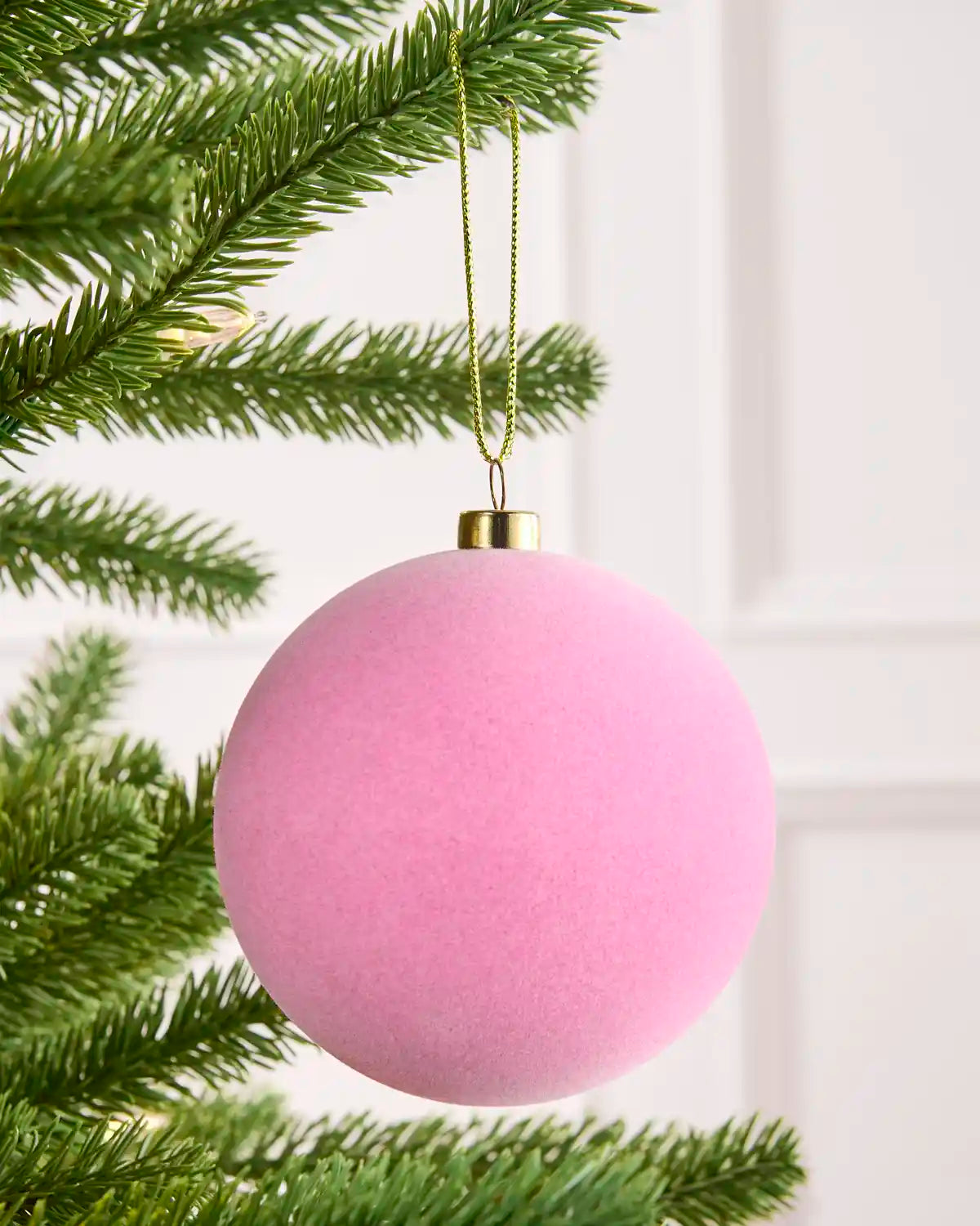 Close-up Pink velvet round shape bauble hanging from Christmas tree