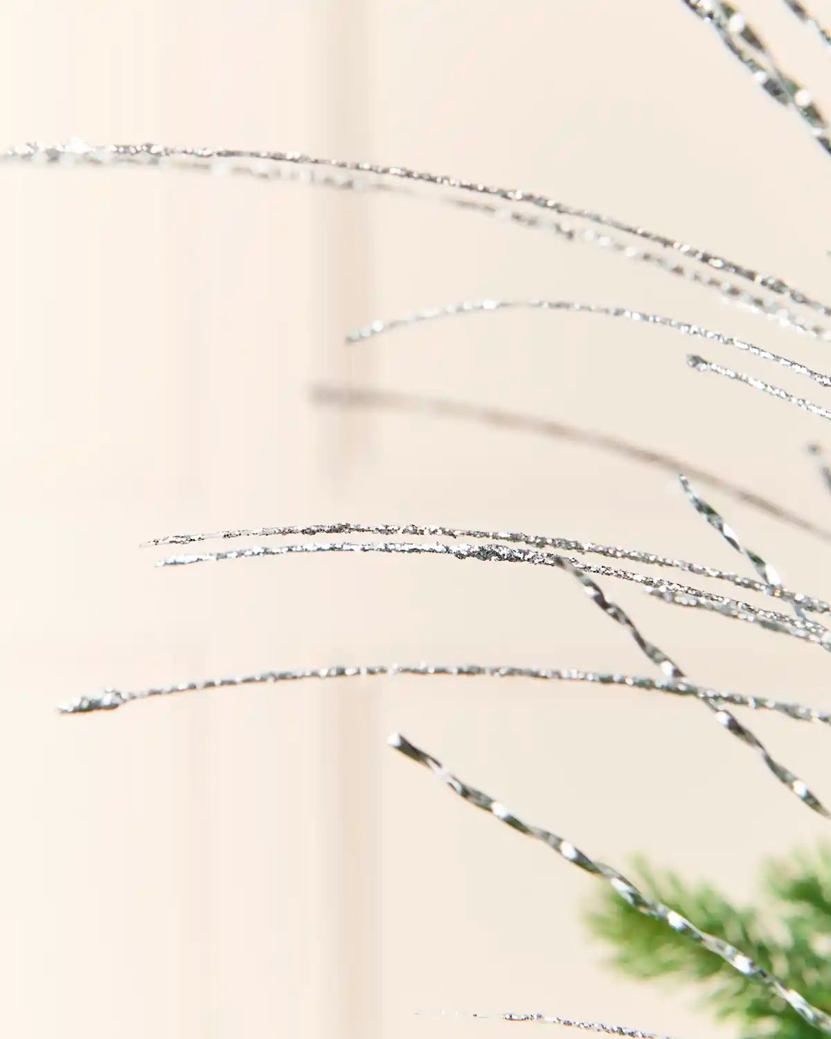 Close-up detail of the Silver Glitter Fountain Christmas Tree Spray, highlighting its delicate glittered strands