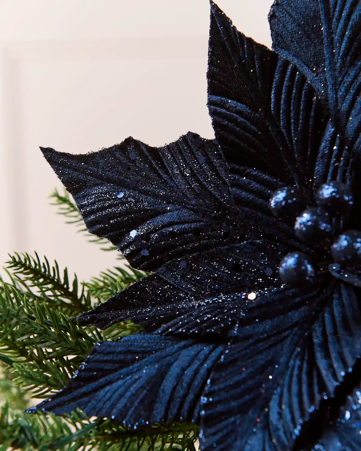 Side view of navy blue glitter poinsettia petals with textured detailing