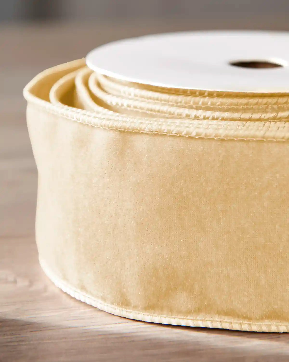 Close-up of 6 cm latte double-sided wired velvet ribbon showing the soft velvet surface and wired edges.
