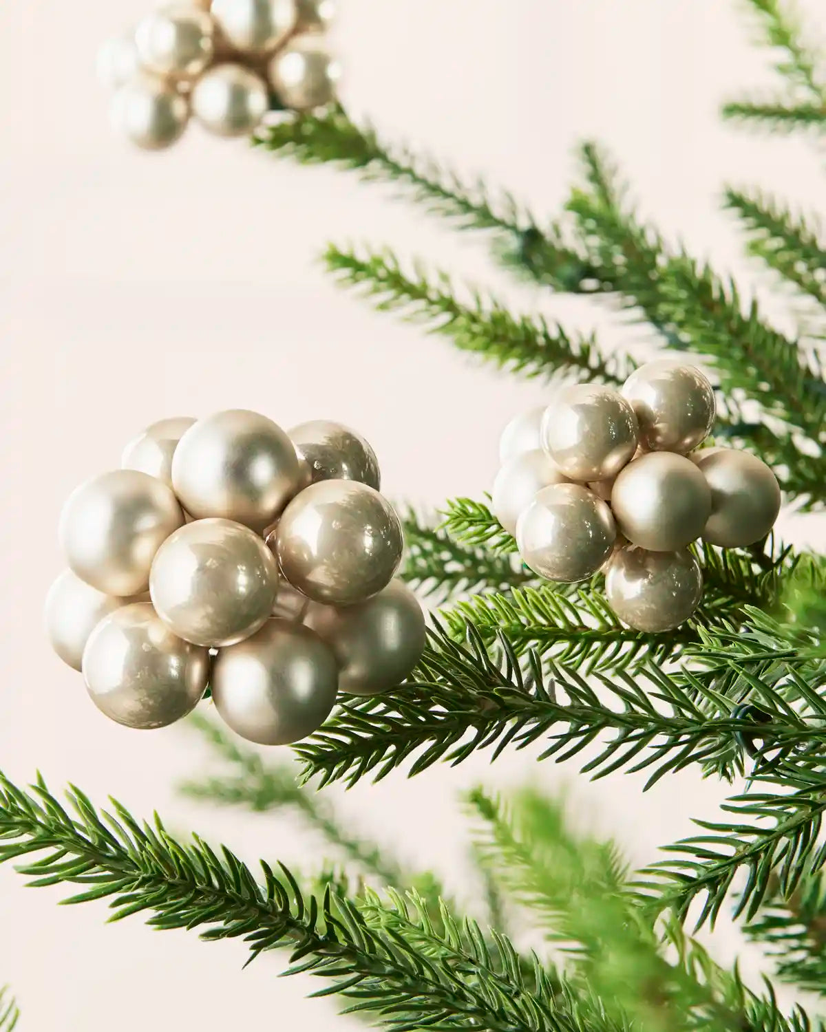 Close-up of Latte glass berry cluster baubles with shiny and matt finishes on a Christmas tree.
