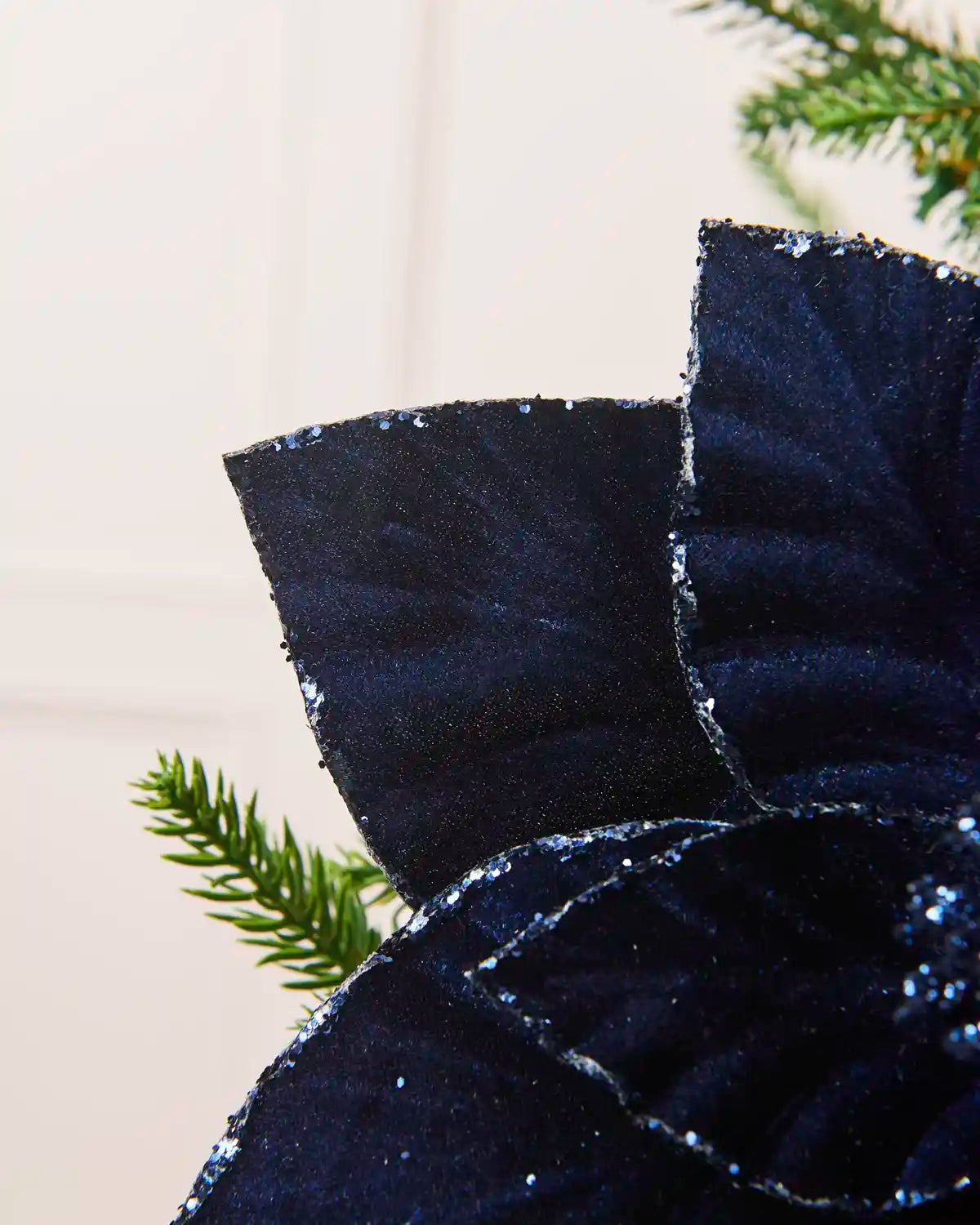 Close-up of Navy  velvet poinsettia petals with glittered edges and center detail
