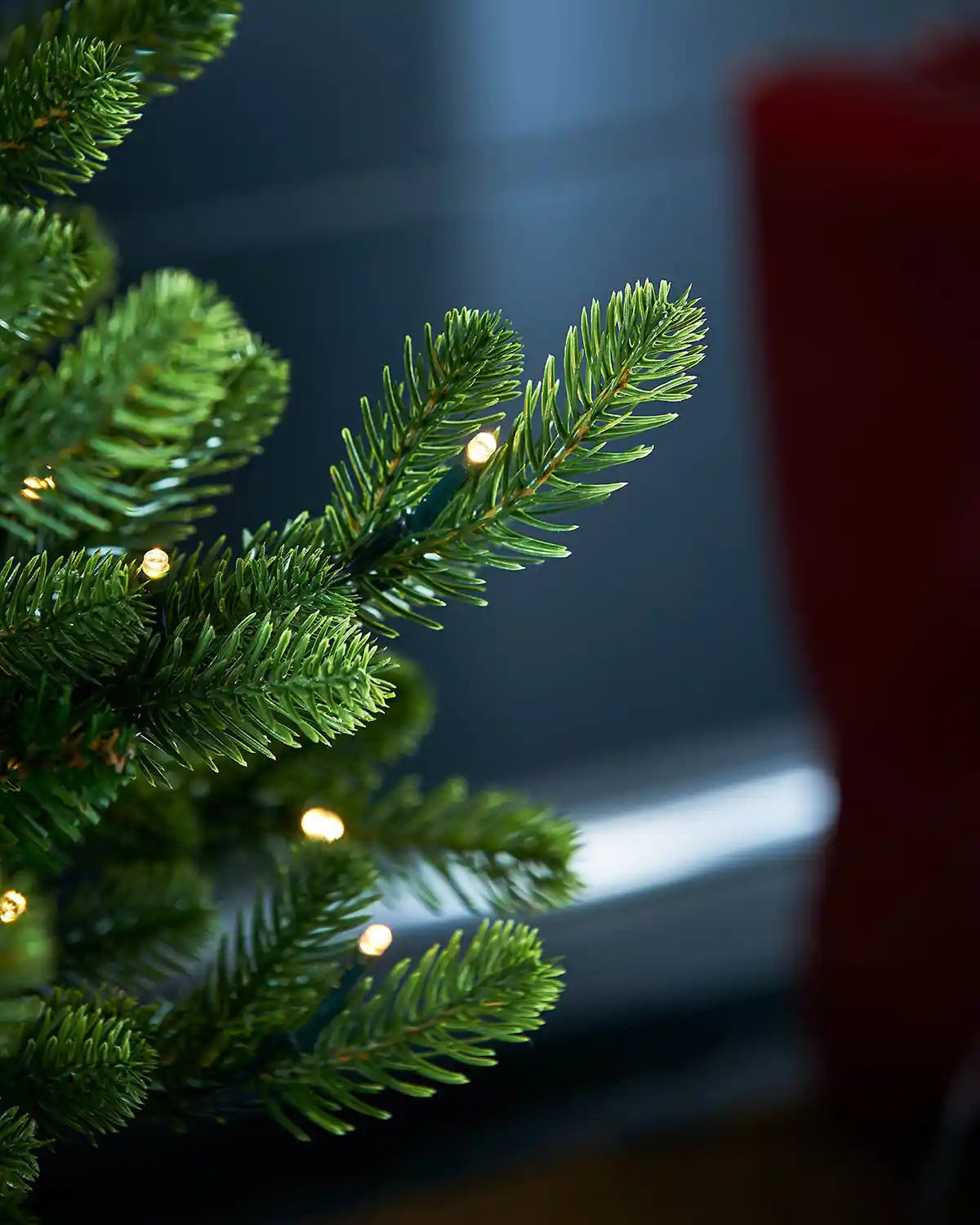 Close-up of PVC and PE tips Christmas tree with lights against a dark background