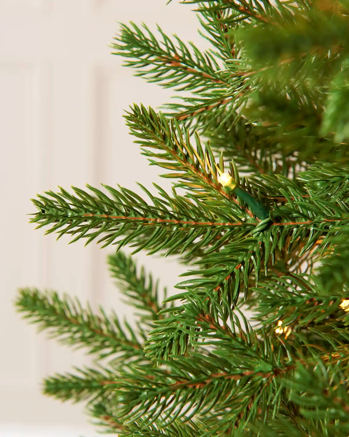 Close-up of Pre-Lit Woodland Pine Christmas Tree, 6.5ft, showing realistic green branches and warm white lights