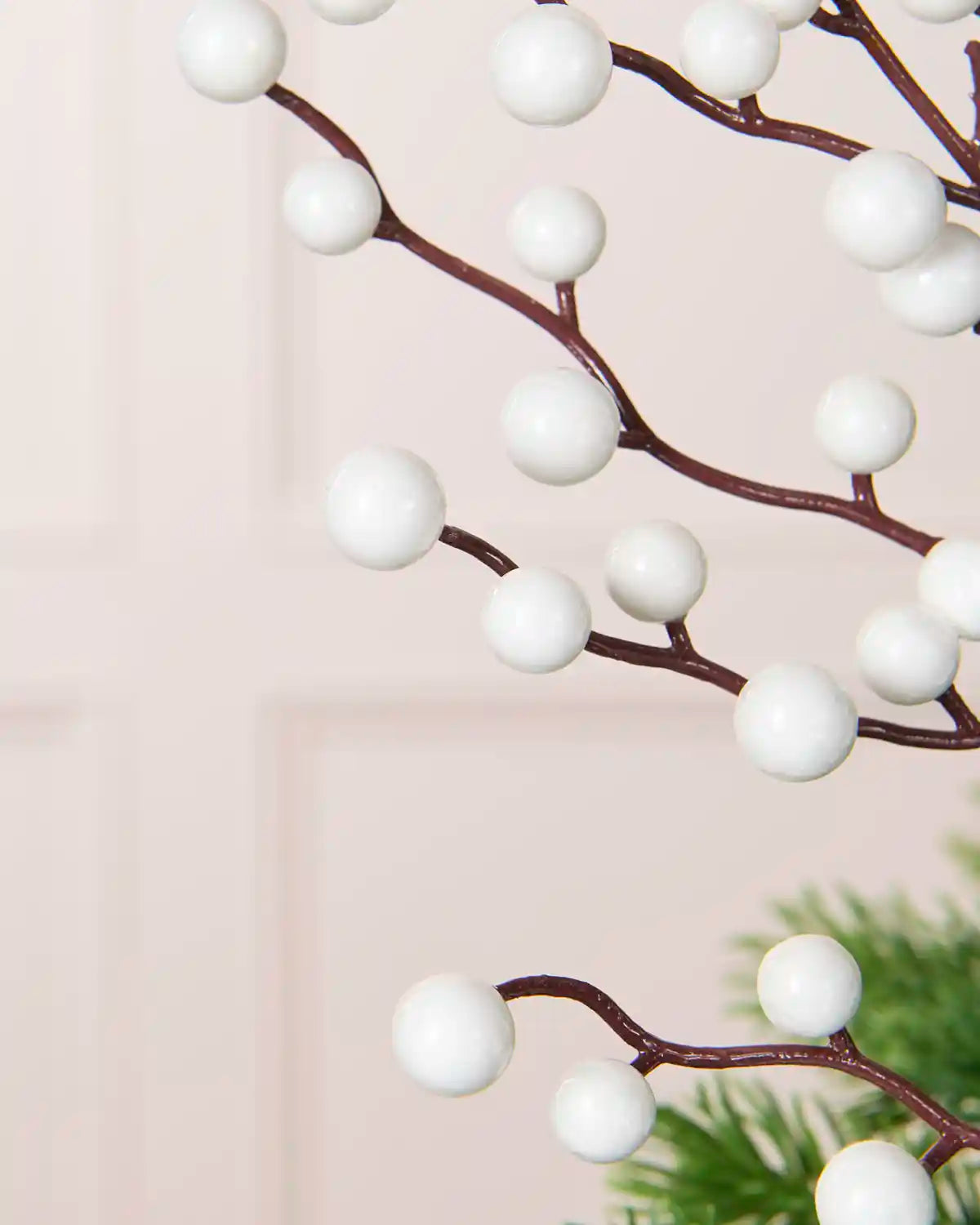 Close-up of White Berries on the White Berry Christmas Tree Pick showing the twig details, with a plain cream background