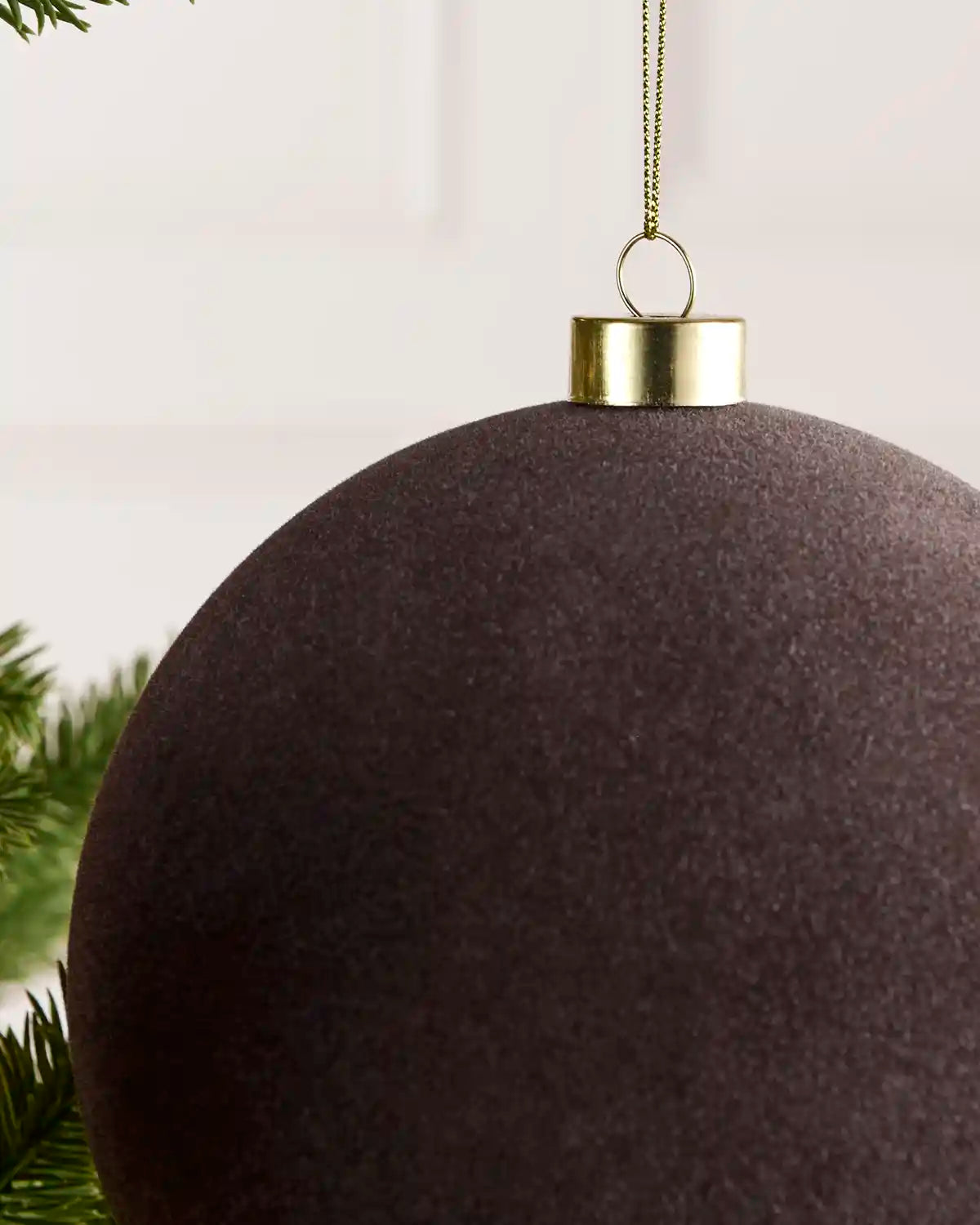 Close-up of a 15 cm Espresso velvet Traditional bauble showing its smooth texture and gold hanging cap.
