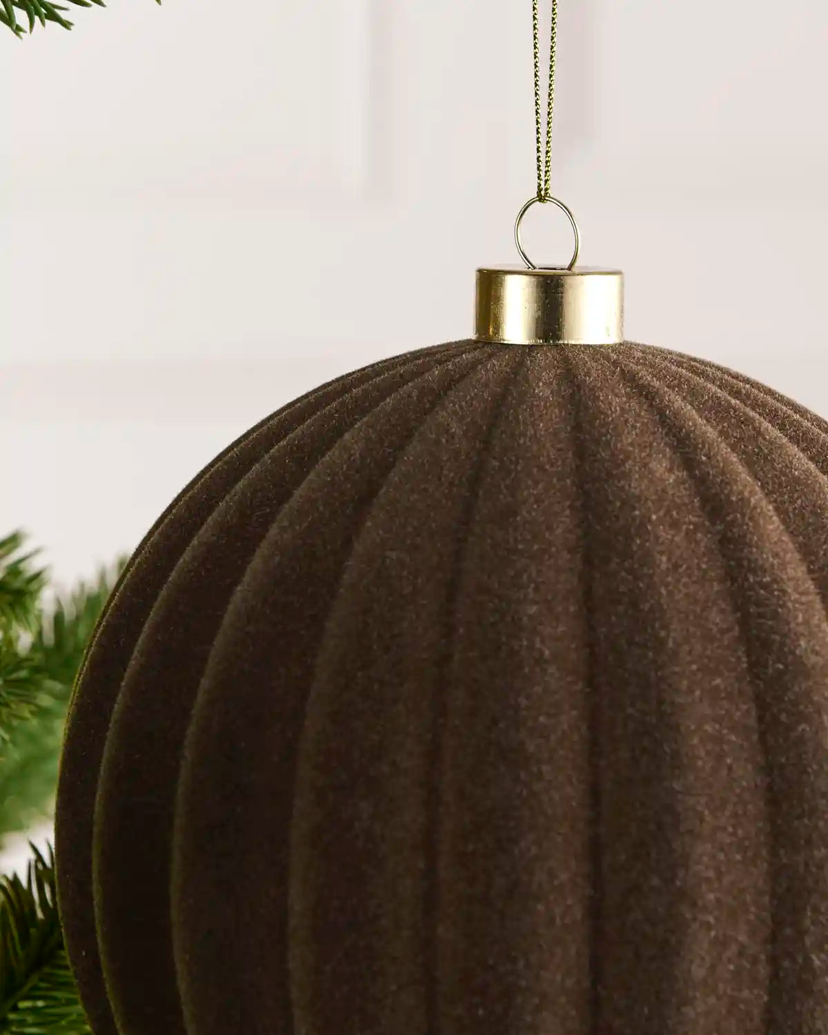 Close-up of a 15 cm Mocha velvet Ribbed bauble showing its Ribbed texture and gold hanging cap.
