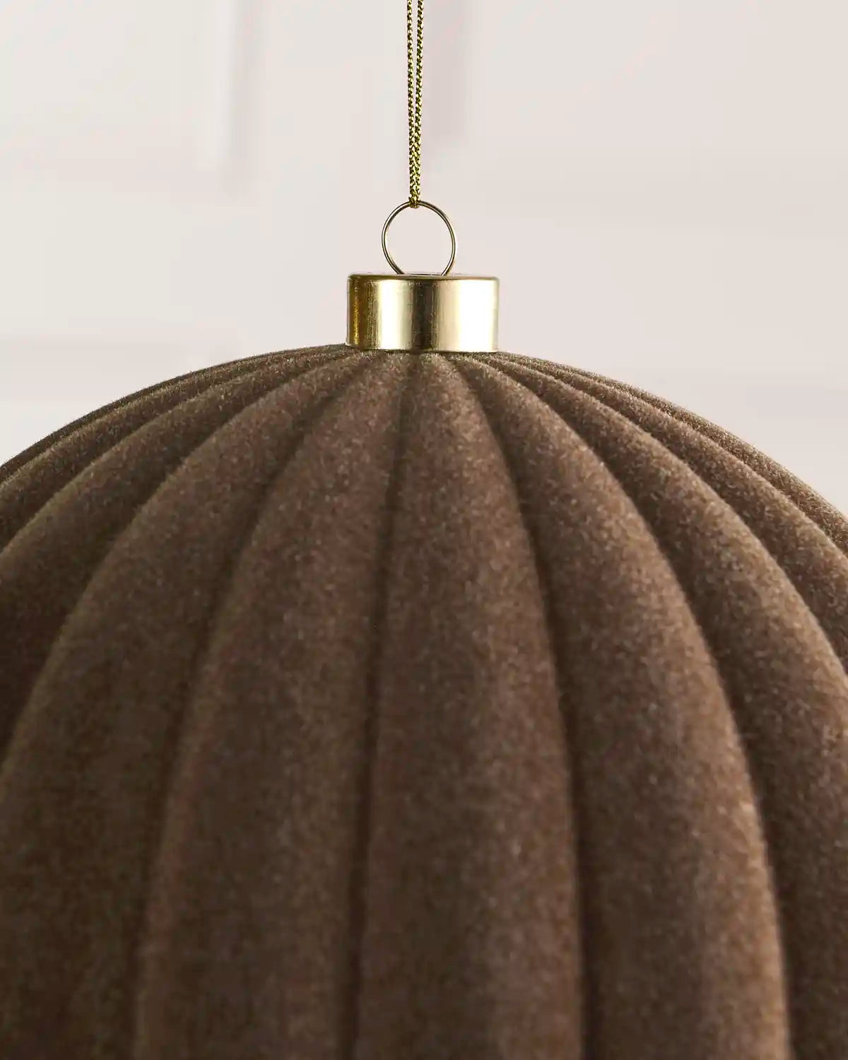 Close-up of a 20 cm Mocha velvet Ribbed bauble showing its Ribbed texture and gold hanging cap.
