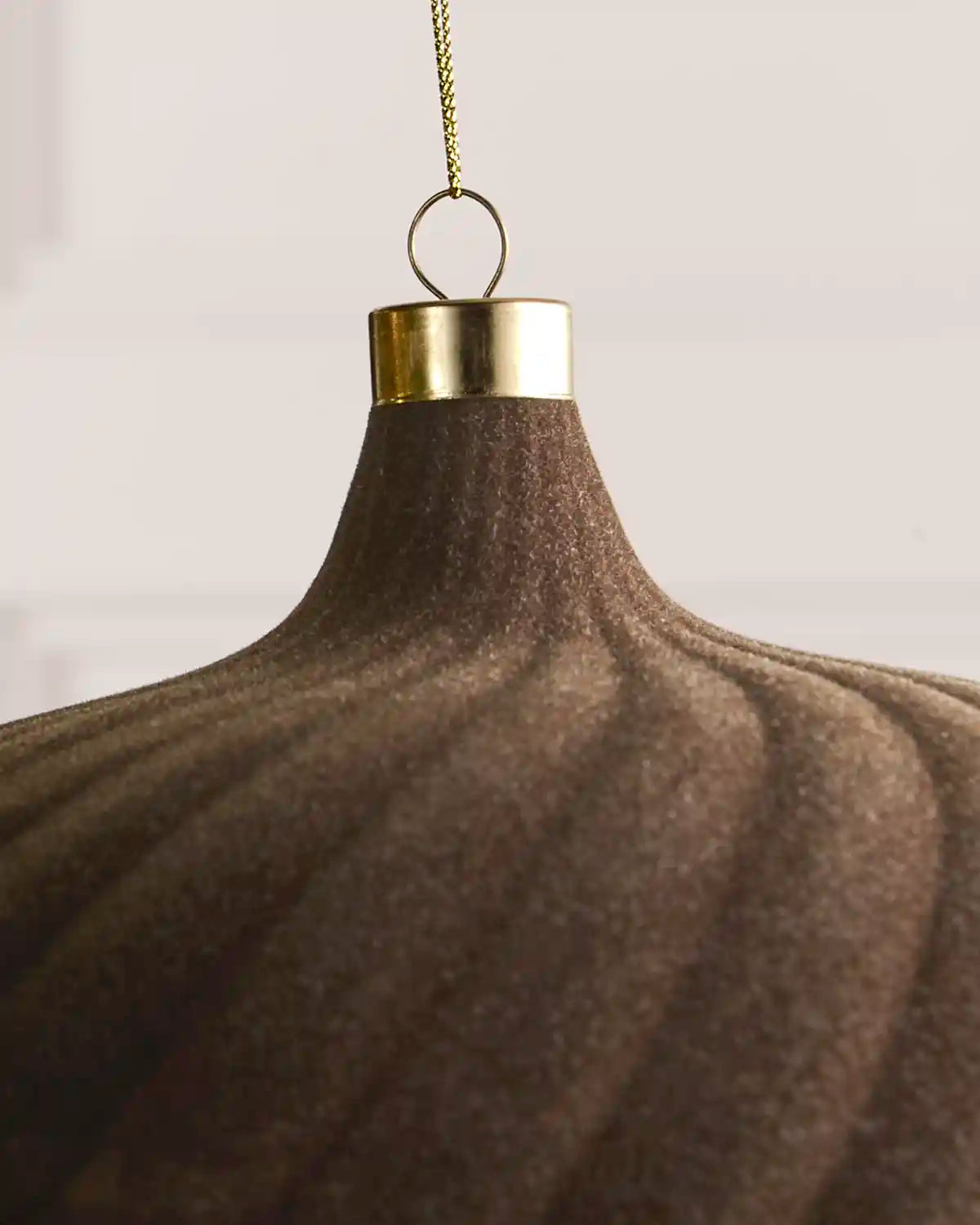Close-up of a 20 cm Mocha velvet Spiral bauble showing its Spiral texture and gold hanging cap.
