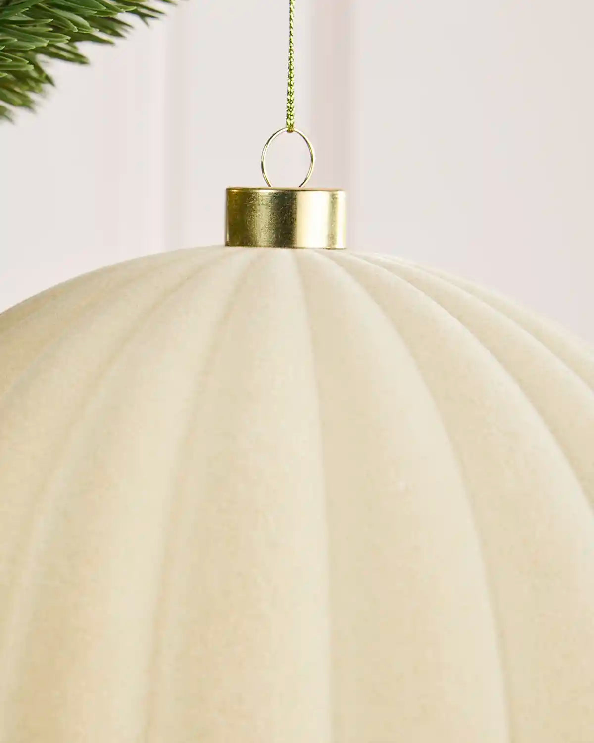 Close-up of a 20 cm latte velvet Ribbed bauble showing its Ribbed texture and gold hanging cap.
