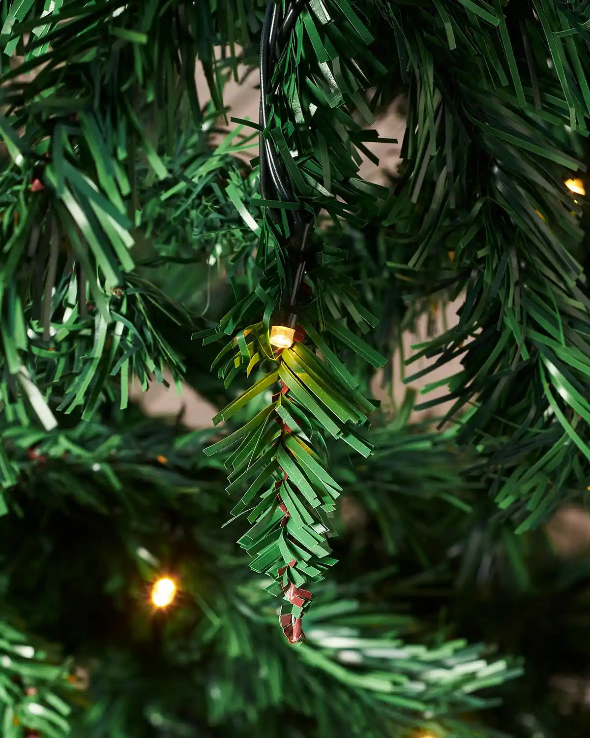 Close-up of a 7ft Christmas tree with warm white lights and PVC and PE tips 
