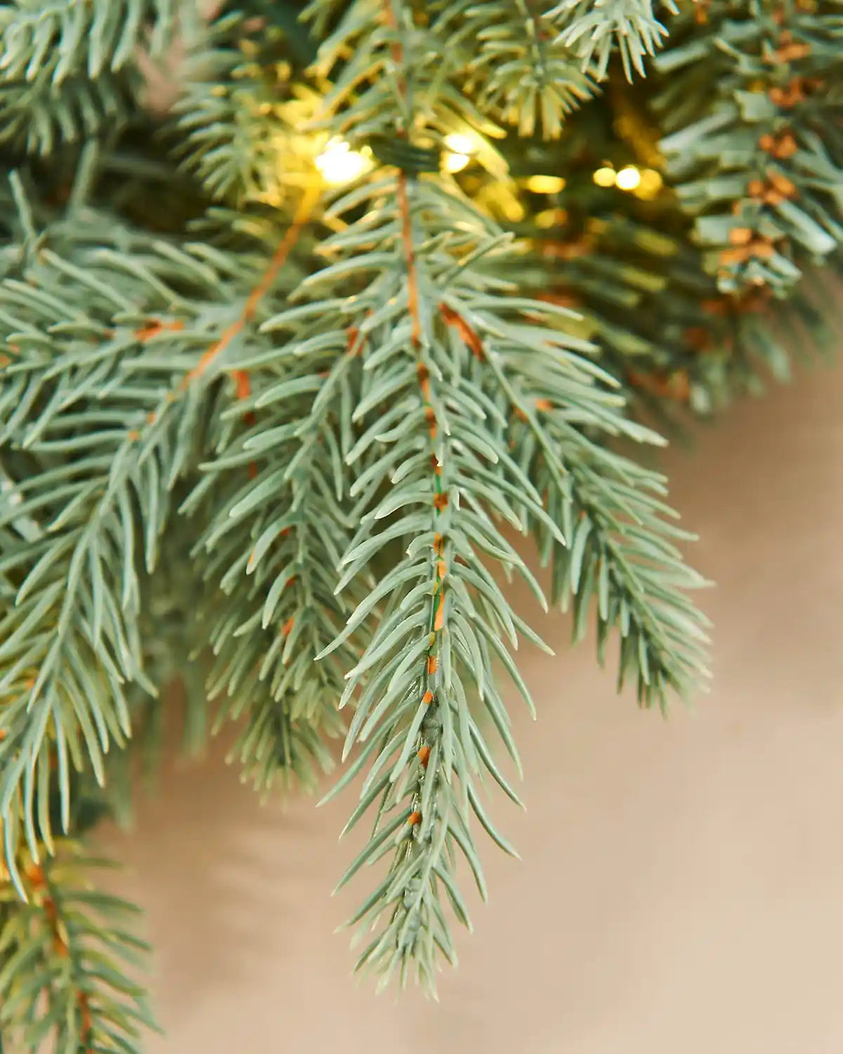 Close-up of a Christmas tree branch with lights on a blurred background