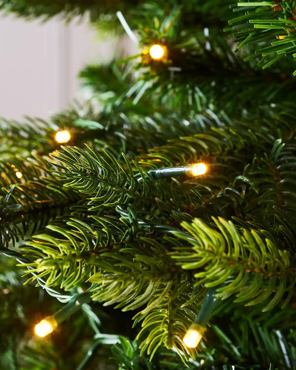 Close-up of a Christmas tree with lights on a blurred background