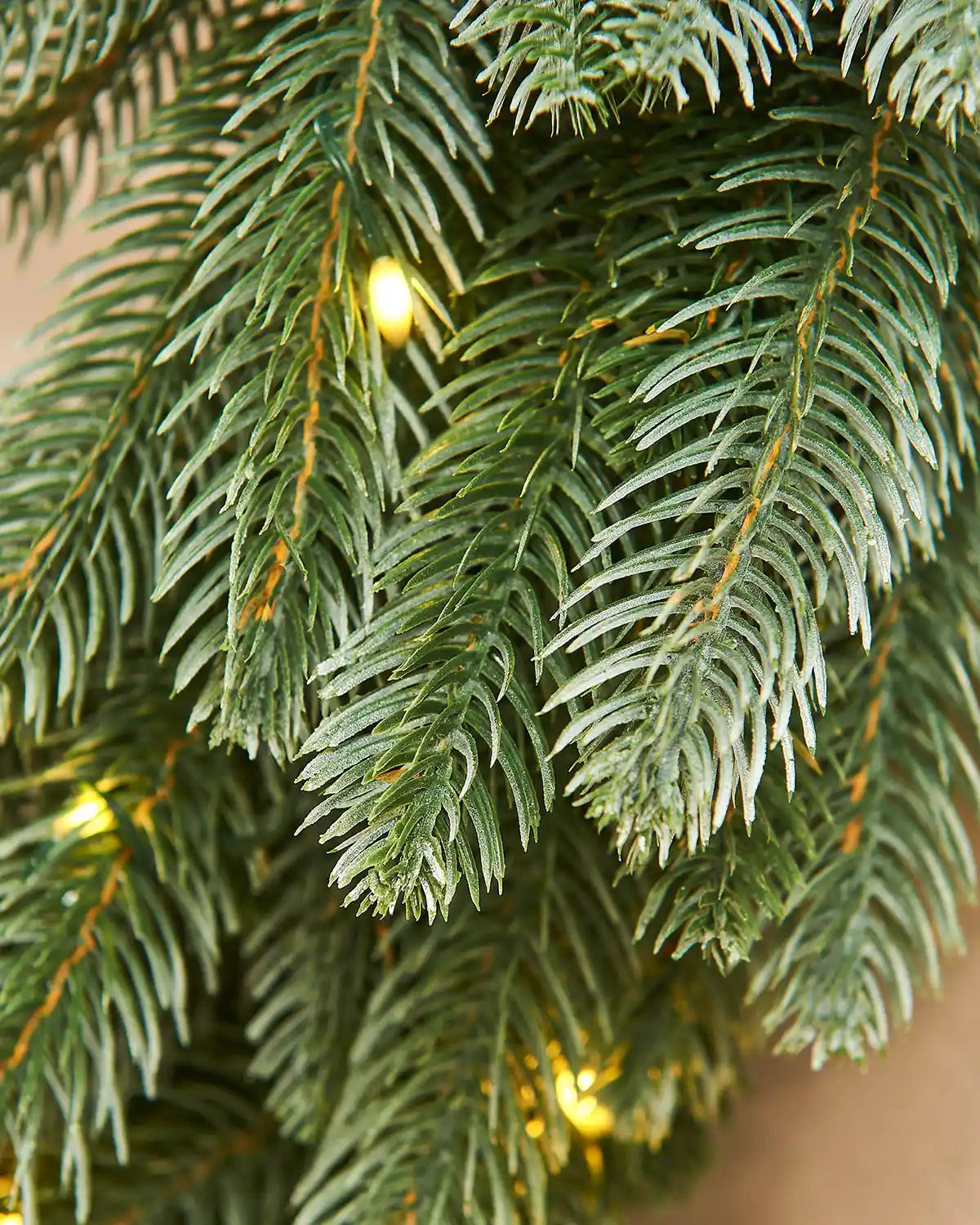 Close-up of a Christmas wreath PVC and PE tips with lights embedded in the branches.