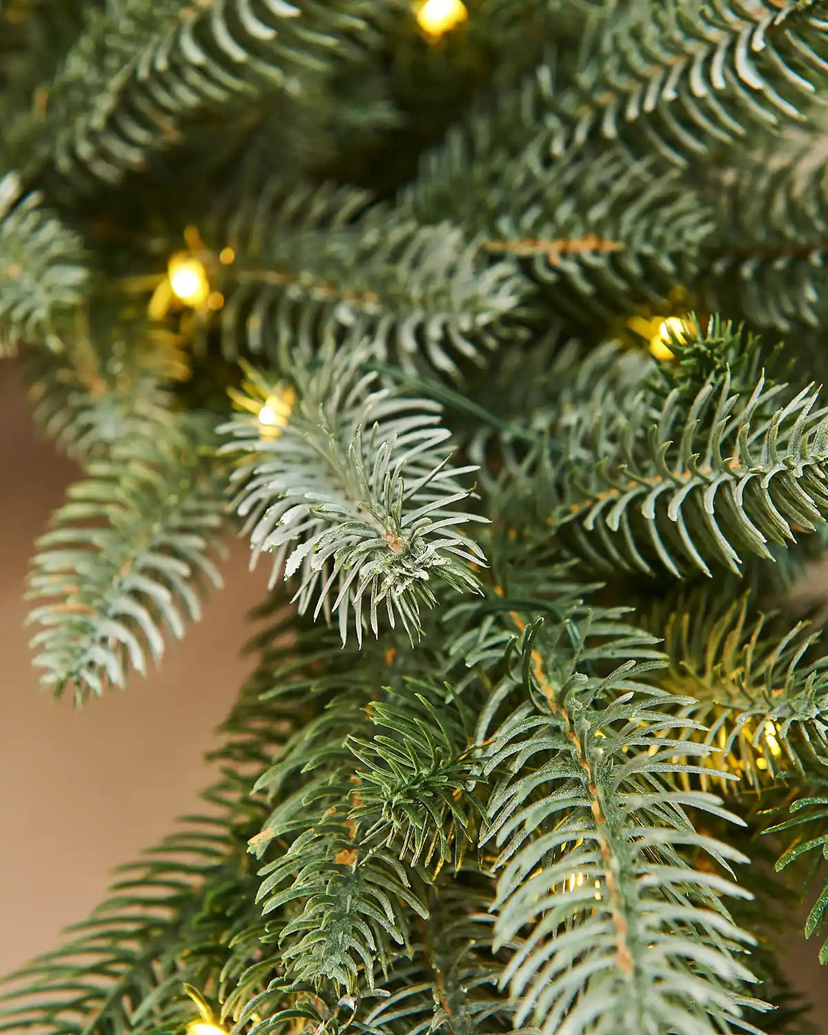 Close-up of a Christmas wreath with lights on a blurred background