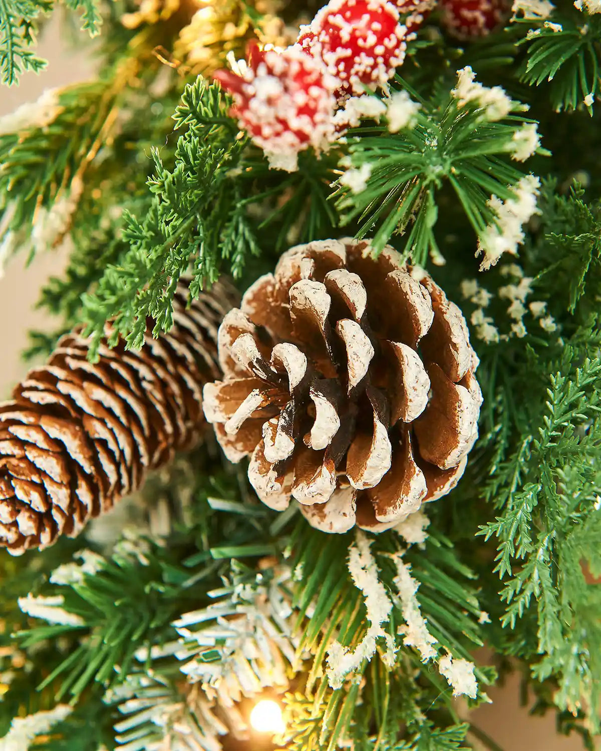 Close-up of a Christmas wreath with pine cones and frosted branches.