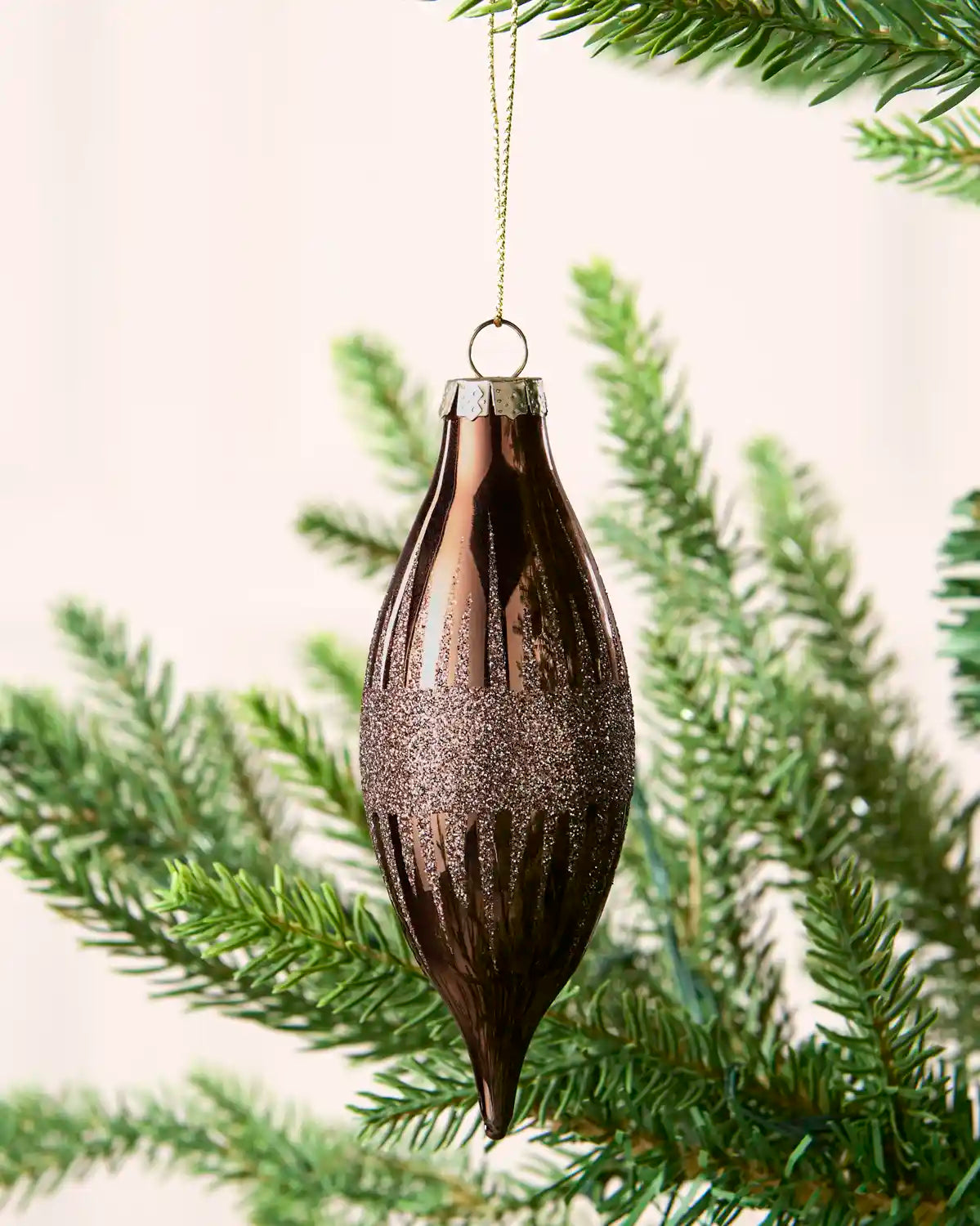 Close-up of a Espresso teardrop glass bauble with glitter lines and a central glitter band.
