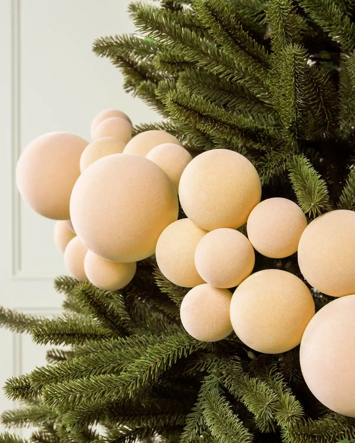Close-up of a Latte Velvet Bauble Garland on a Christmas tree, featuring soft latte velvet baubles.