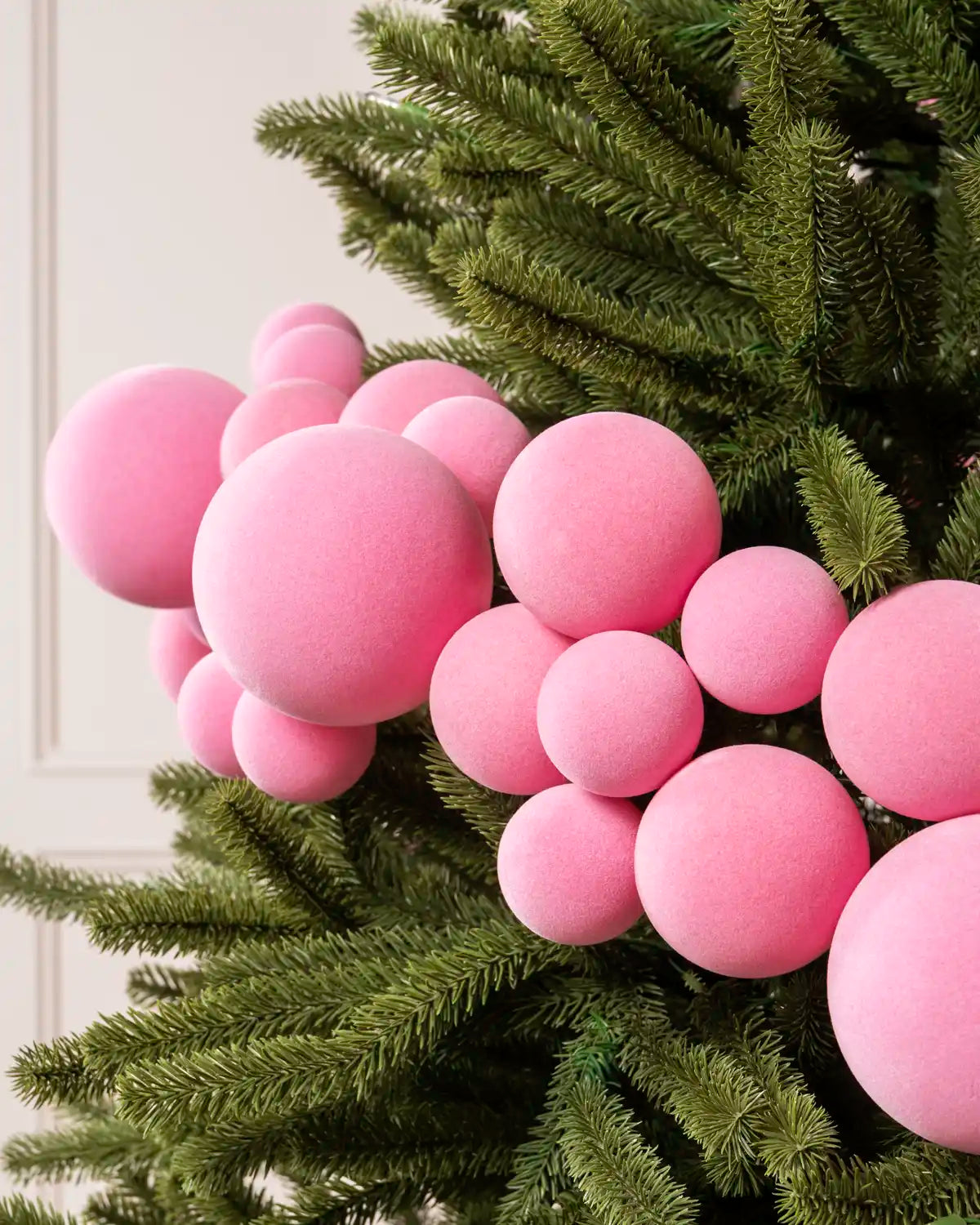 Close-up of a Pink Velvet Bauble Garland on a Christmas tree, featuring soft pink velvet baubles.
