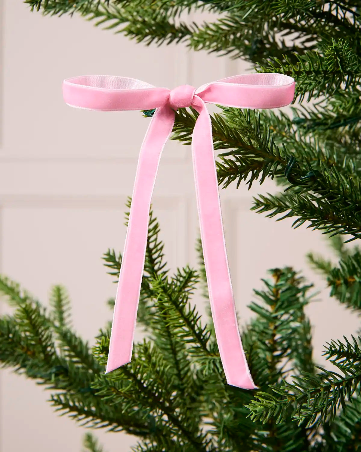 Close-up of a Pink Velvet Bow attached to a Christmas tree branch