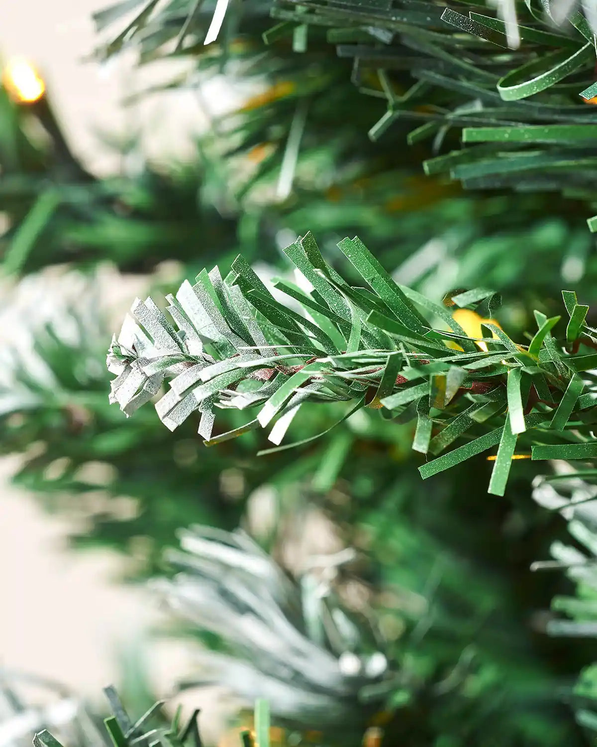 Close-up of a Pre-Lit Frosted Mixed Pine Christmas Tree, 7ft with warm white lights and PVC and PE tips 