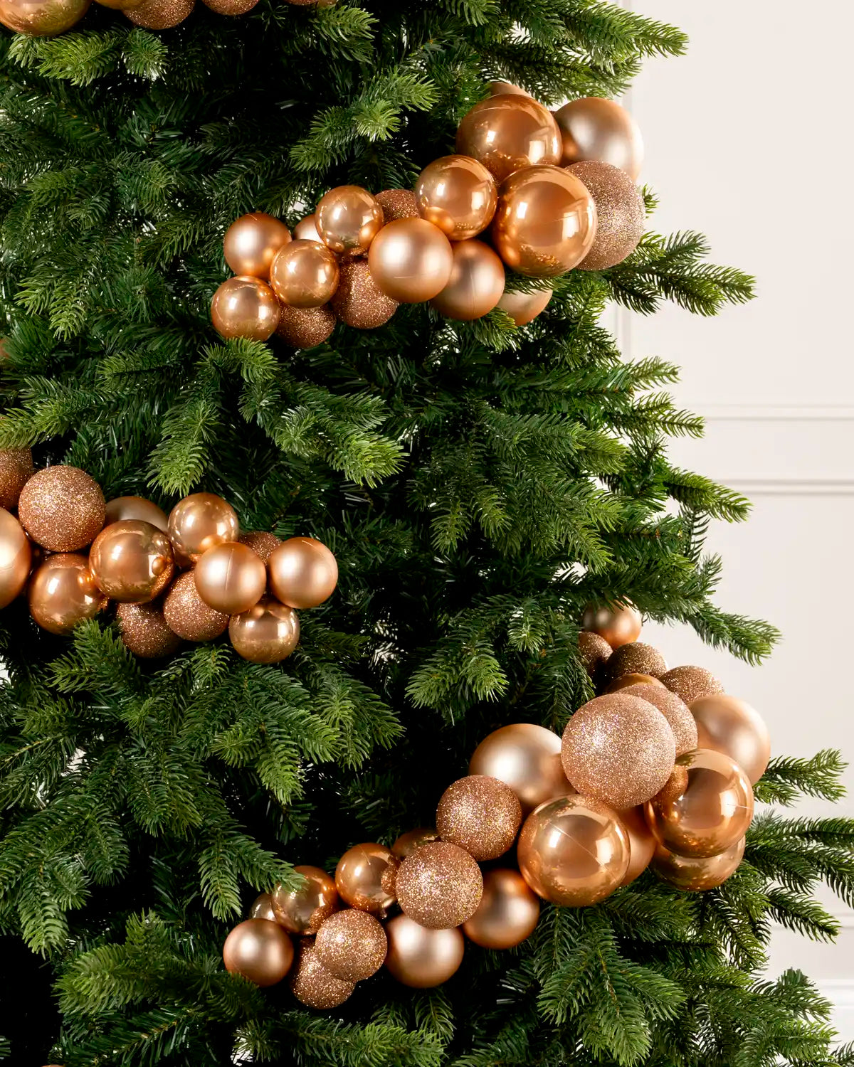 Close-up of a Rose Gold Bauble Cluster Arch on a Christmas tree