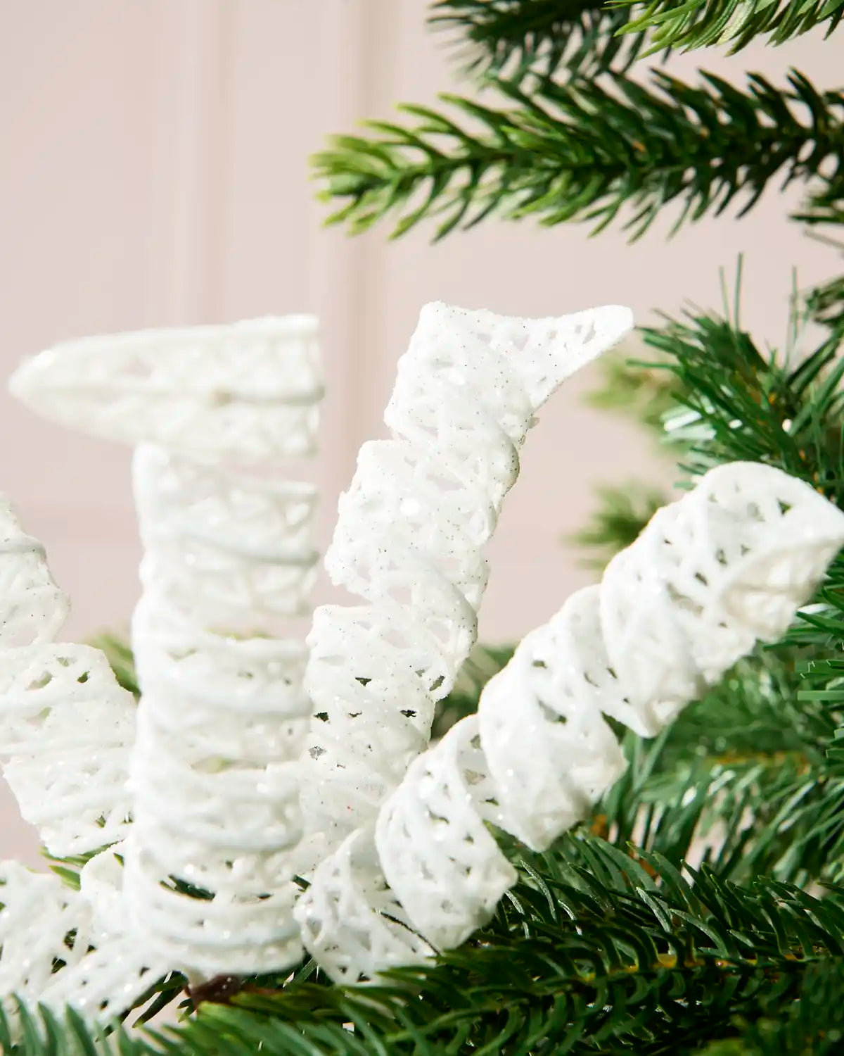 Close-up of a White Glitter Spiral Pick attached to a Christmas tree branch