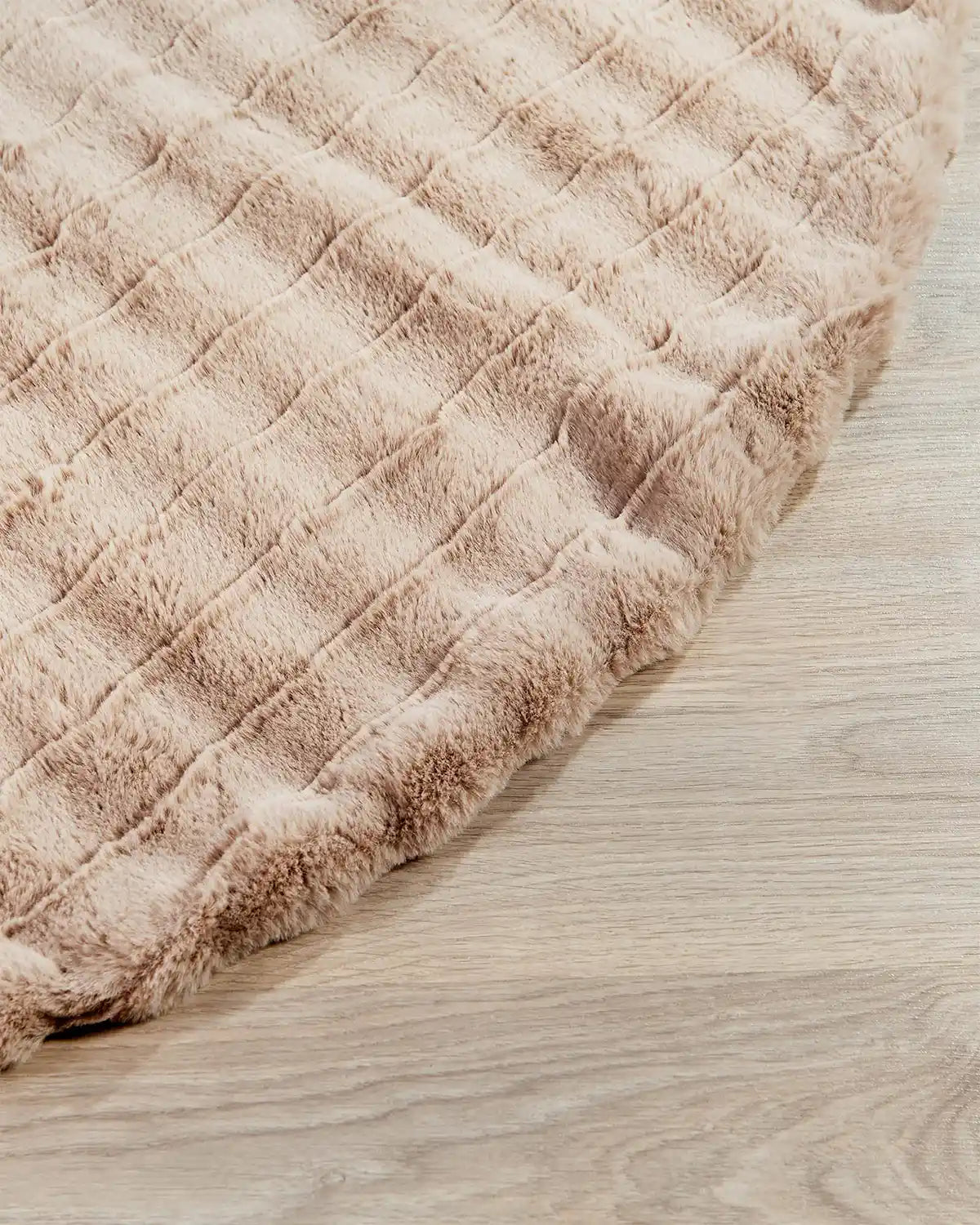 Close-up of a beige quilted mat on a wooden floor