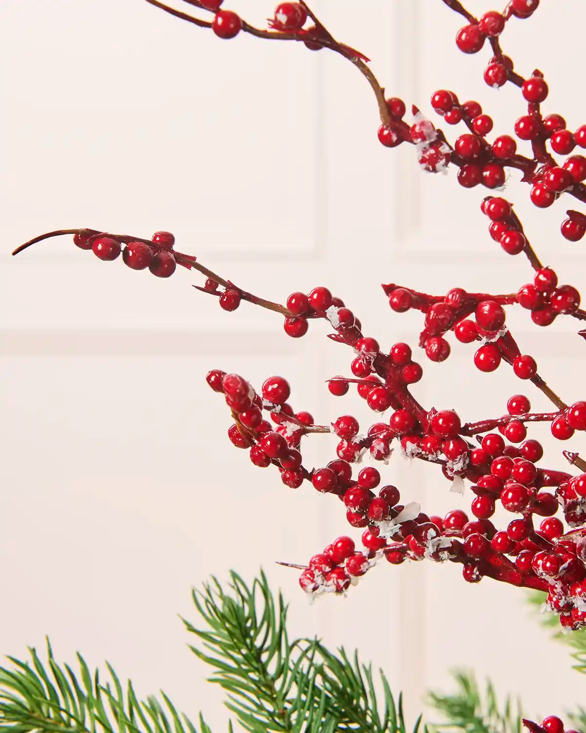Close-up of a frosted red berry Christmas tree pick featuring red berries on branching stems with white frosted detailing.