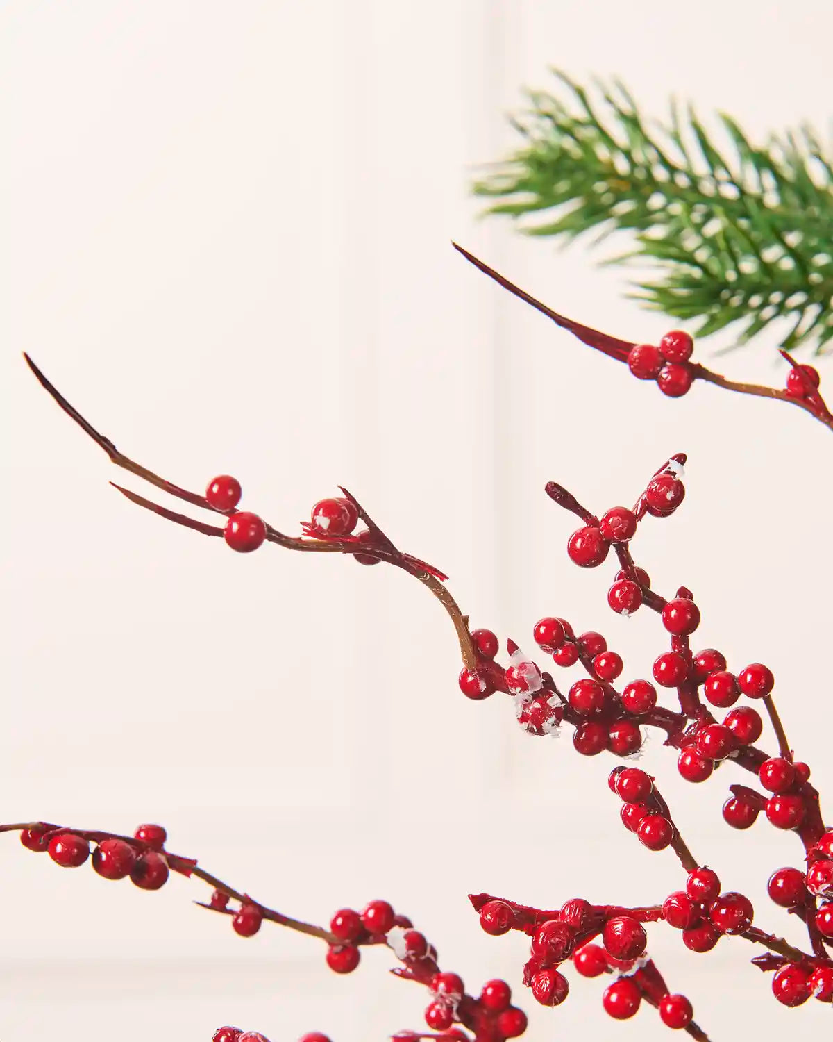 Close-up of a frosted red berry Christmas tree pick showing glossy red berries clustered along brown branches with white frosted details.
