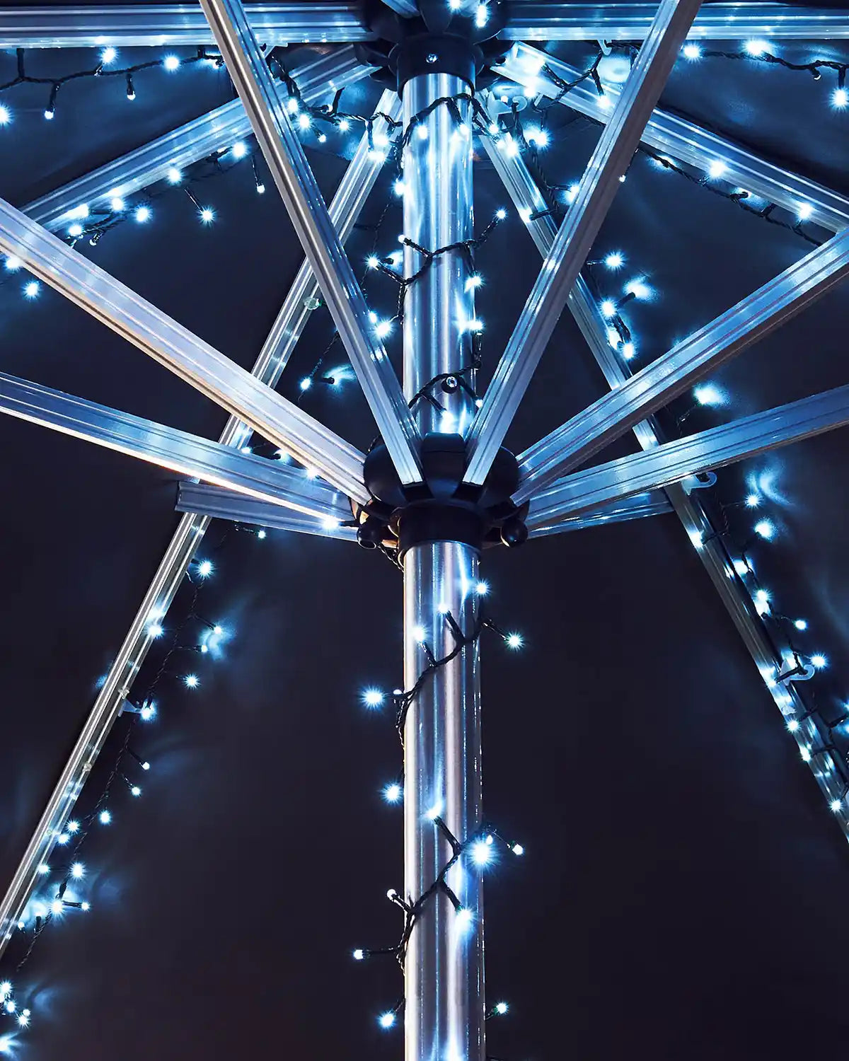 Close-up of a metallic umbrella with ice white LED lights against a dark background