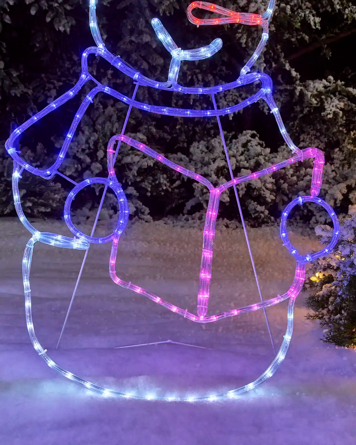 Close-up of a pre-lit snowman rope light silhouette wearing a Santa hat and scarf, glowing in purple and pink lights