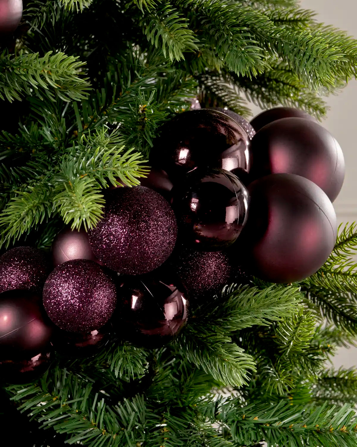 Close-up of burgundy baubles in a Burgundy Bauble Cluster Arch, featuring glitter, matte, and glossy finishes